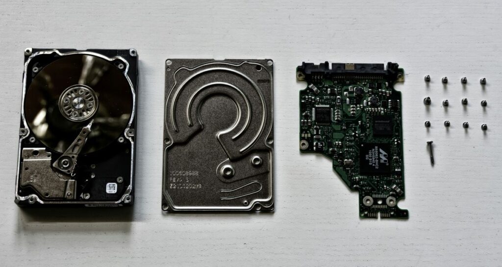 Hard disk aperto smontato in tre parti: case, disco interno e scheda PCB, rappresentazione dei livelli del dispositivo